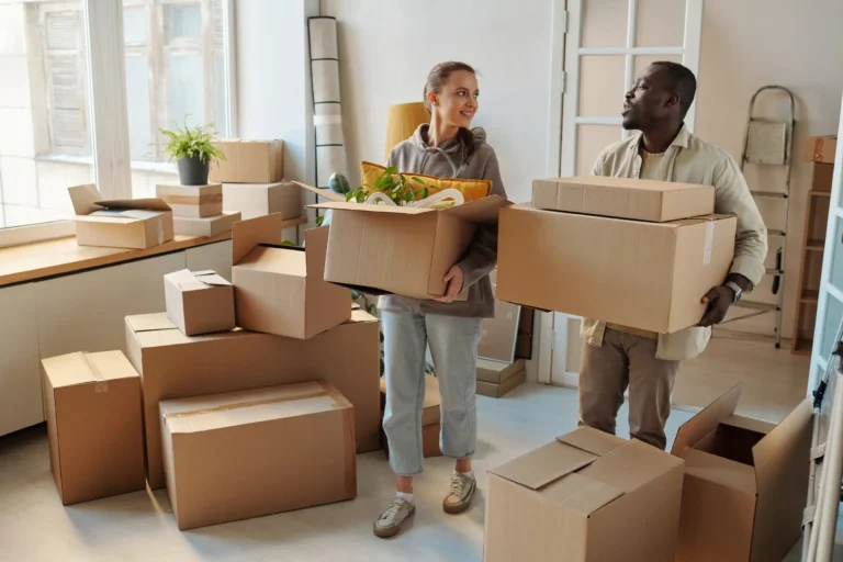 Couple carrying boxes on their new apartment.