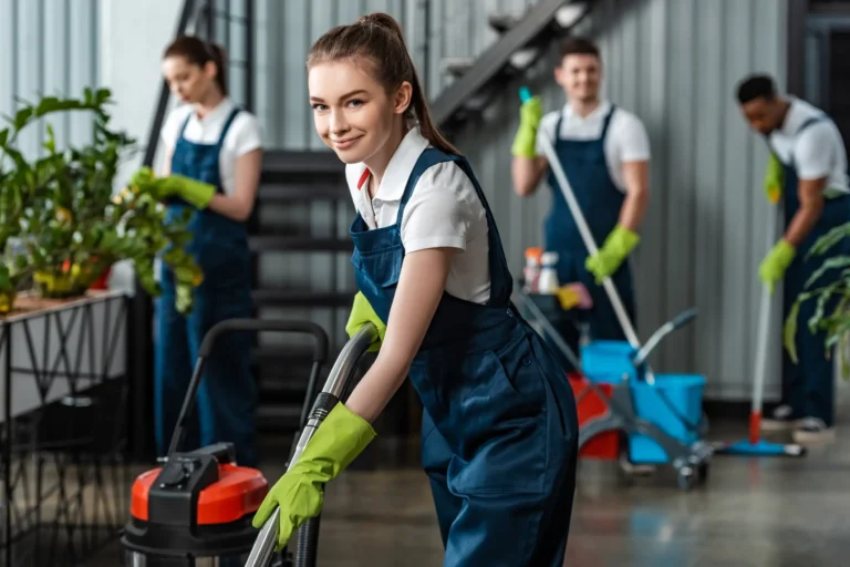 A smiling lady with her co-workers in the floor office.